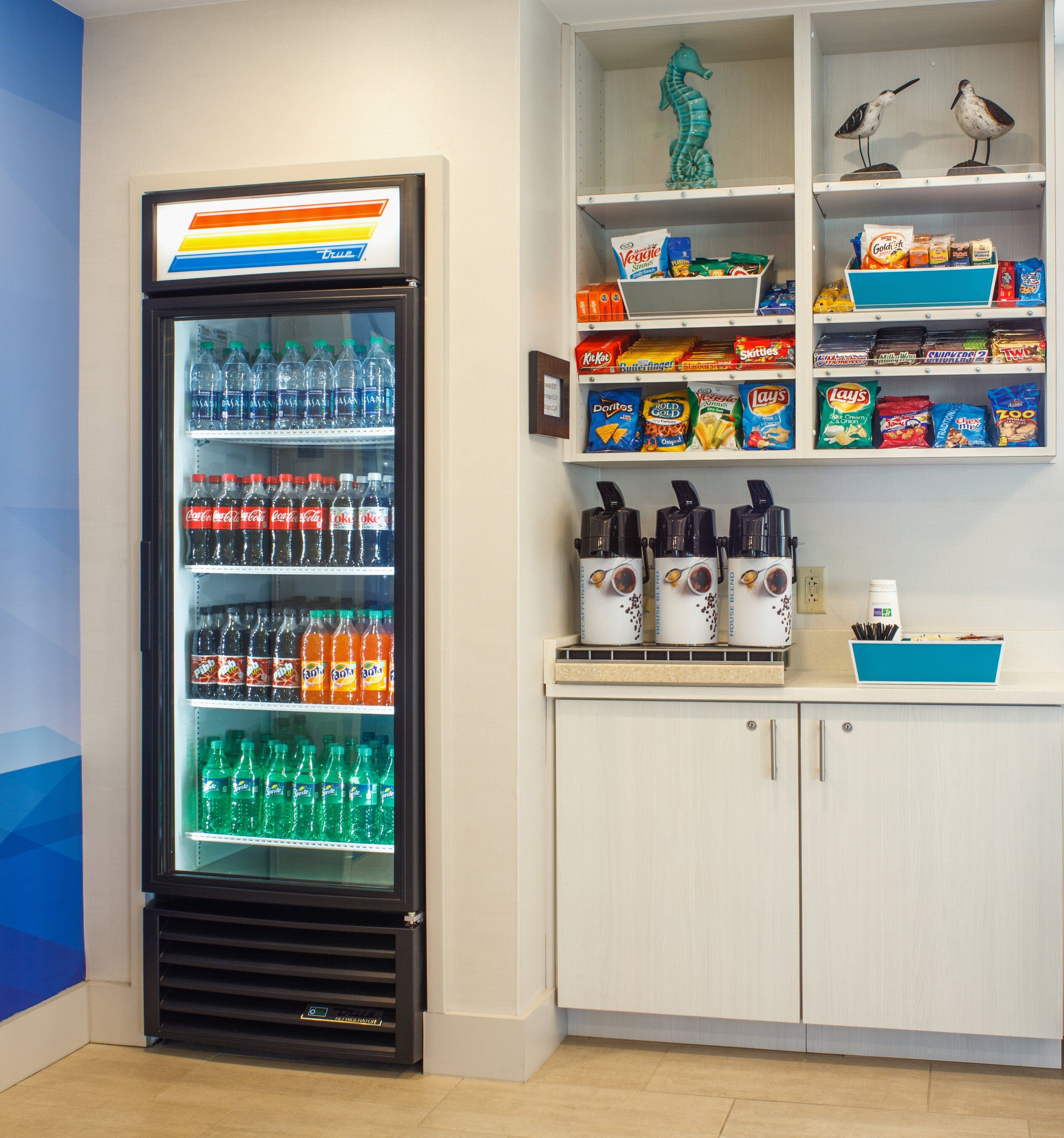 A vending machine stocked with various beverages and snacks, including Fanta, Coca-Cola, and Doritos.