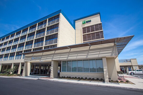 A modern hotel with a flat facade, large windows, and a covered entrance. - Holiday Inn Express Nags Head Oceanfront by IHG (Nags Head)