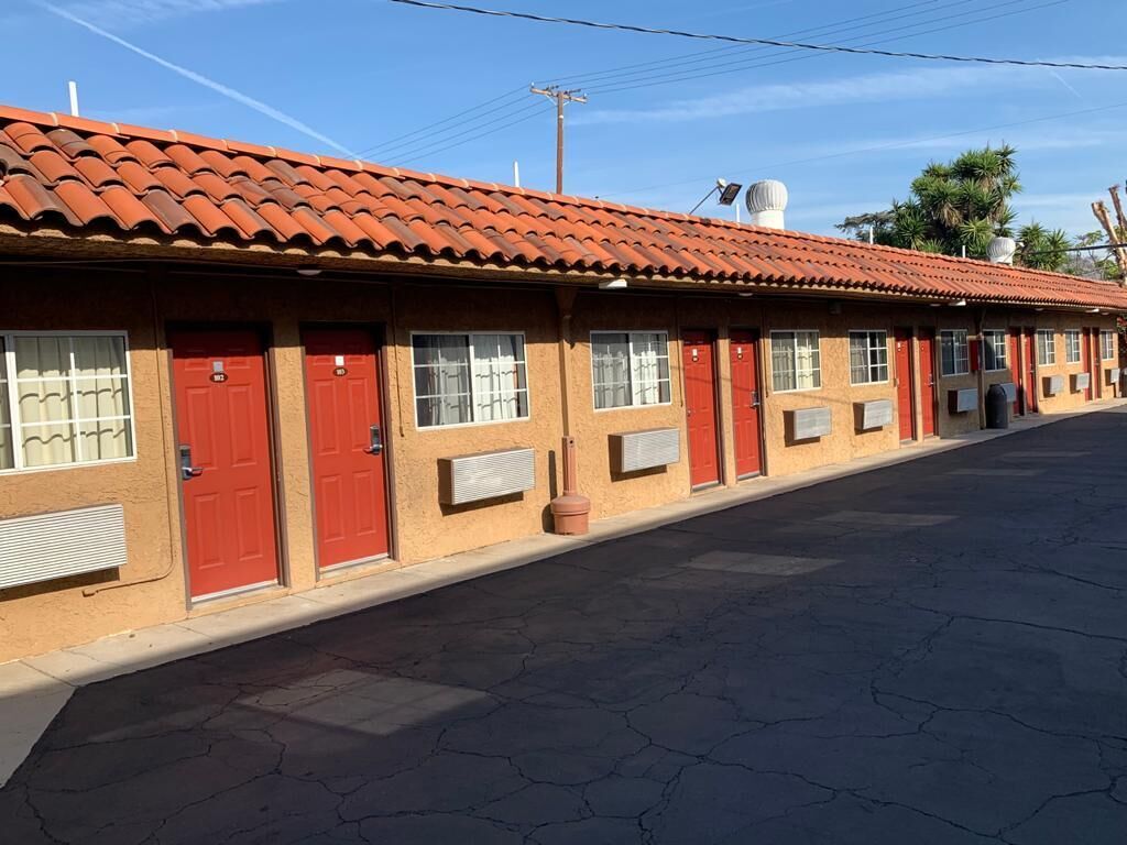 A row of single-story buildings with red doors and windows, each with a small air conditioning unit.