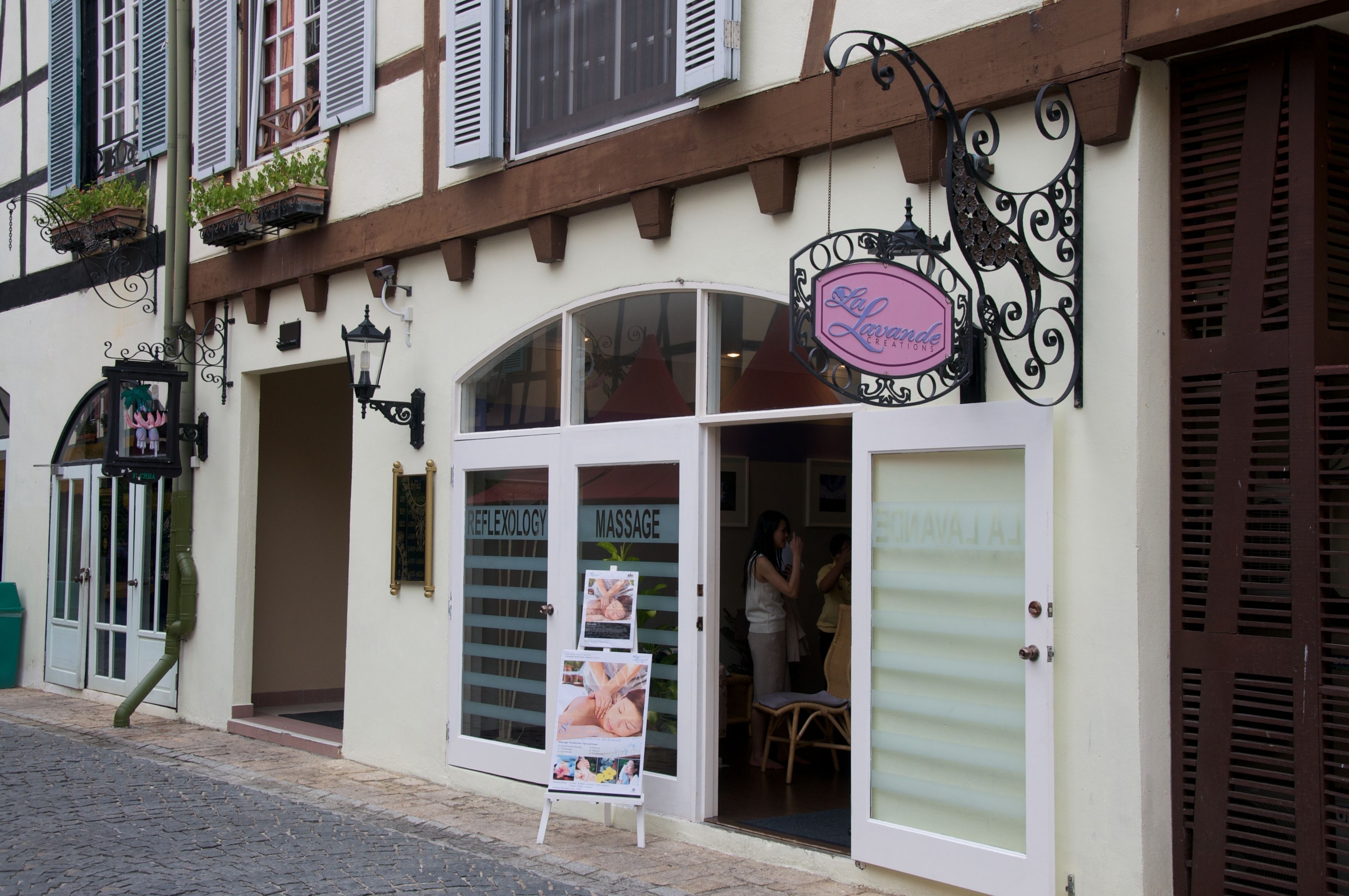 A building with a sign reading "La Lavanda" and a door labeled "REFLEXOLOGY MASSAGE."
