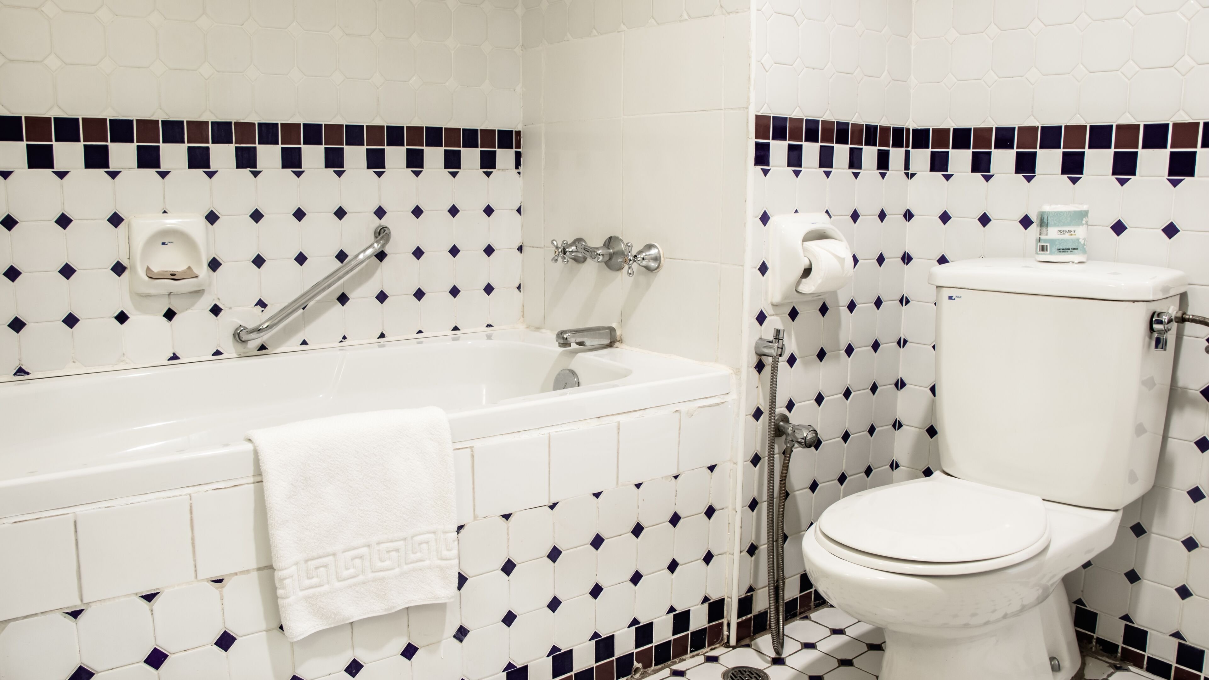 Et badeværelse med badekar, toilet og brusebad.