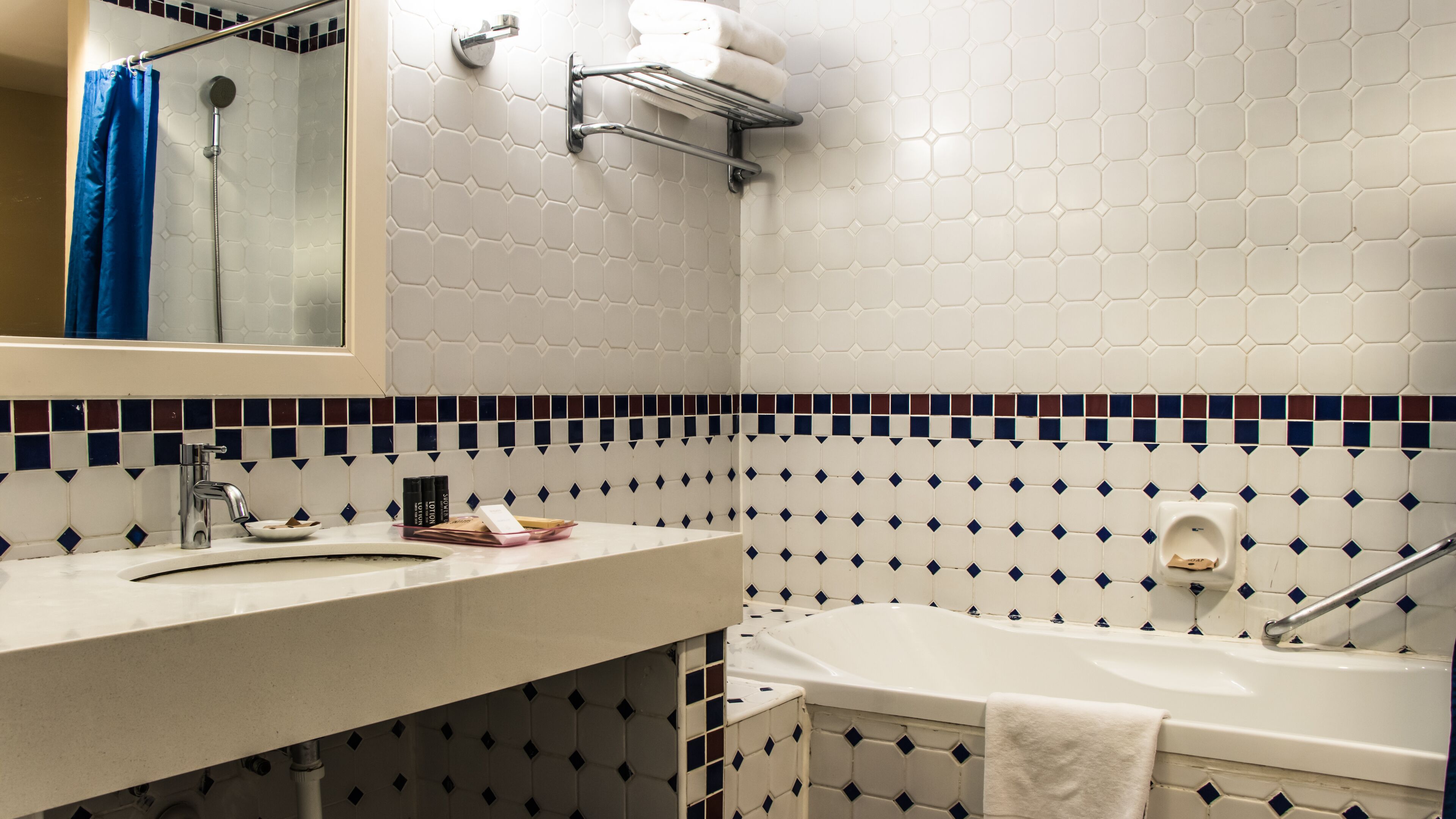 Un baño con lavamanos blanco, espejo, ducha y bañera.