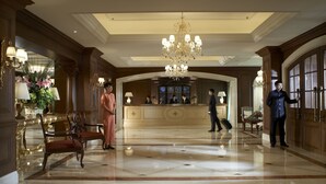 A grand lobby with a marble floor, a large chandelier, and a reception desk. - The Ritz-Carlton, Beijing (Beijing)