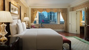 A hotel room with a large bed, two bedside lamps, a small table with a vase, and a view of a cityscape through the window. - The Ritz-Carlton, Beijing (Beijing)