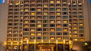 A multi-story hotel with a grid of windows, a central entrance, and illuminated exterior lighting. - The Ritz-Carlton, Beijing (Beijing)