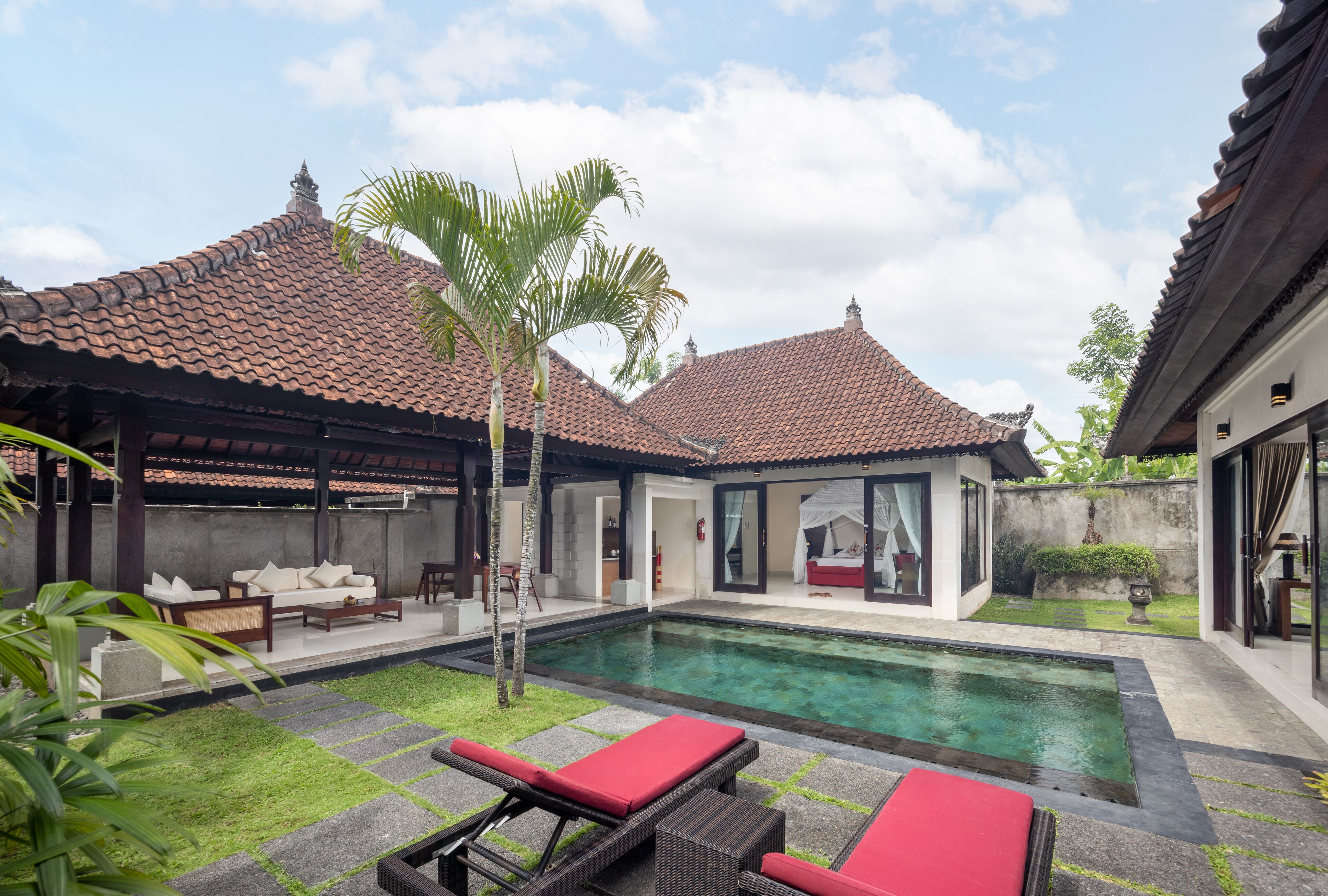 A modern villa with a swimming pool, outdoor seating, and a well-maintained garden.