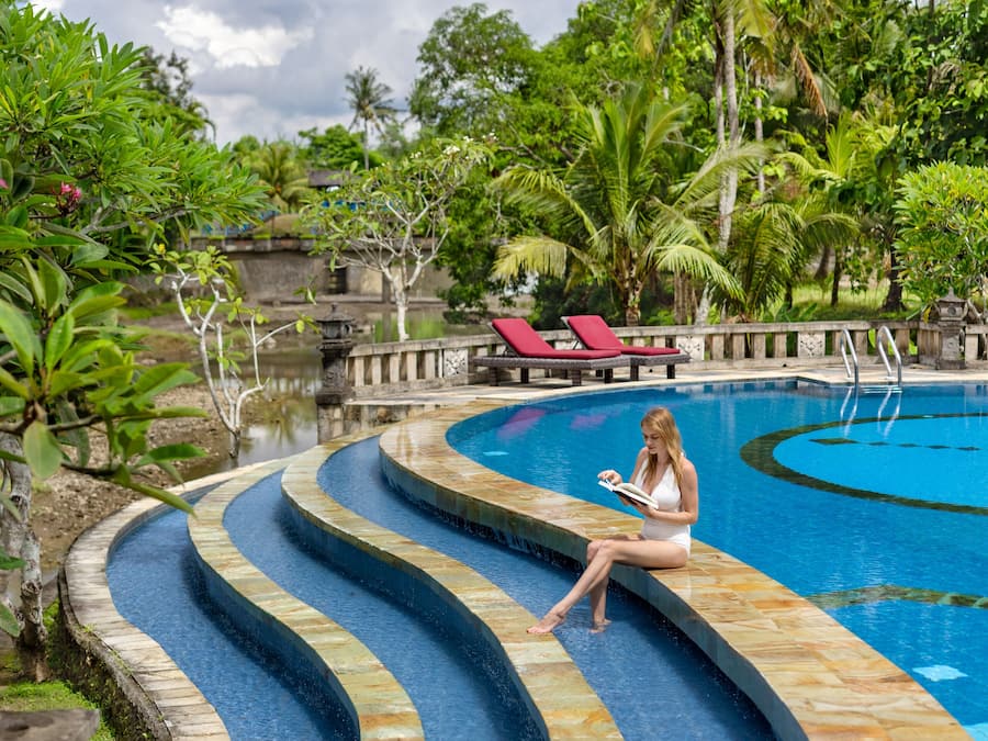 Una piscina al aire libre, sillones reclinables de piscina