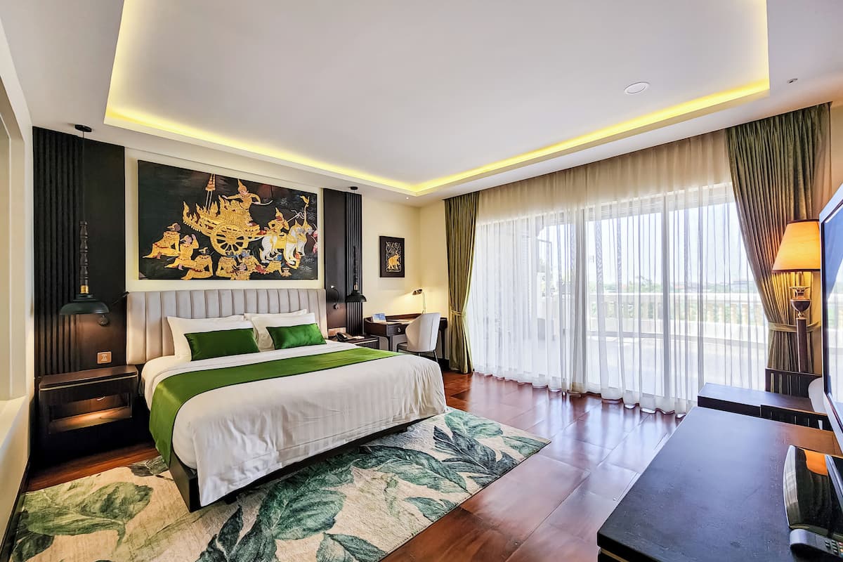 Une chambre d’hôtel moderne dotée d’un grand lit, d’un bureau et offrant une vue sur la ville.