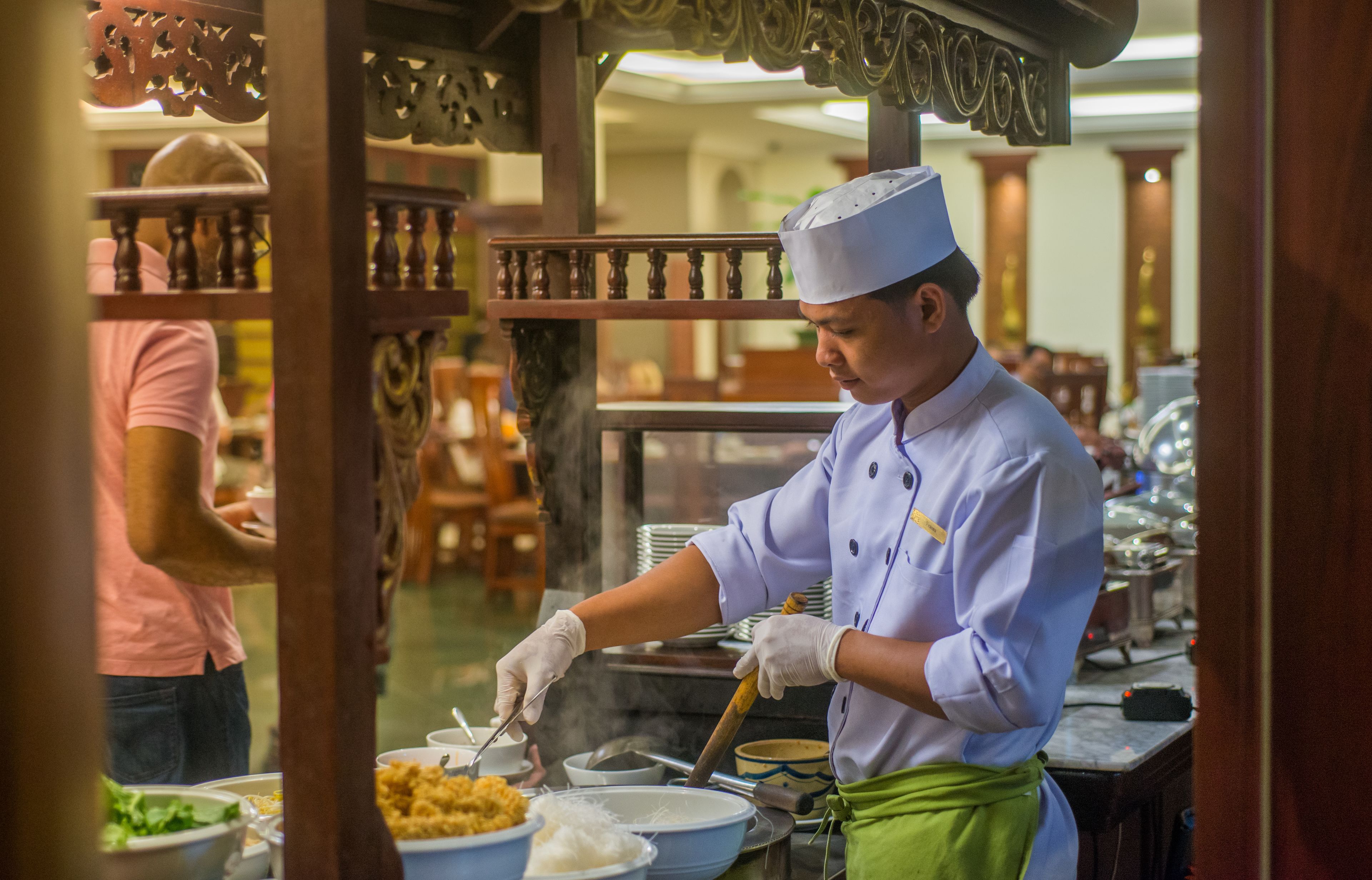 Un chef preparando comida en un restaurante con decoración de madera y un interior tradicional.