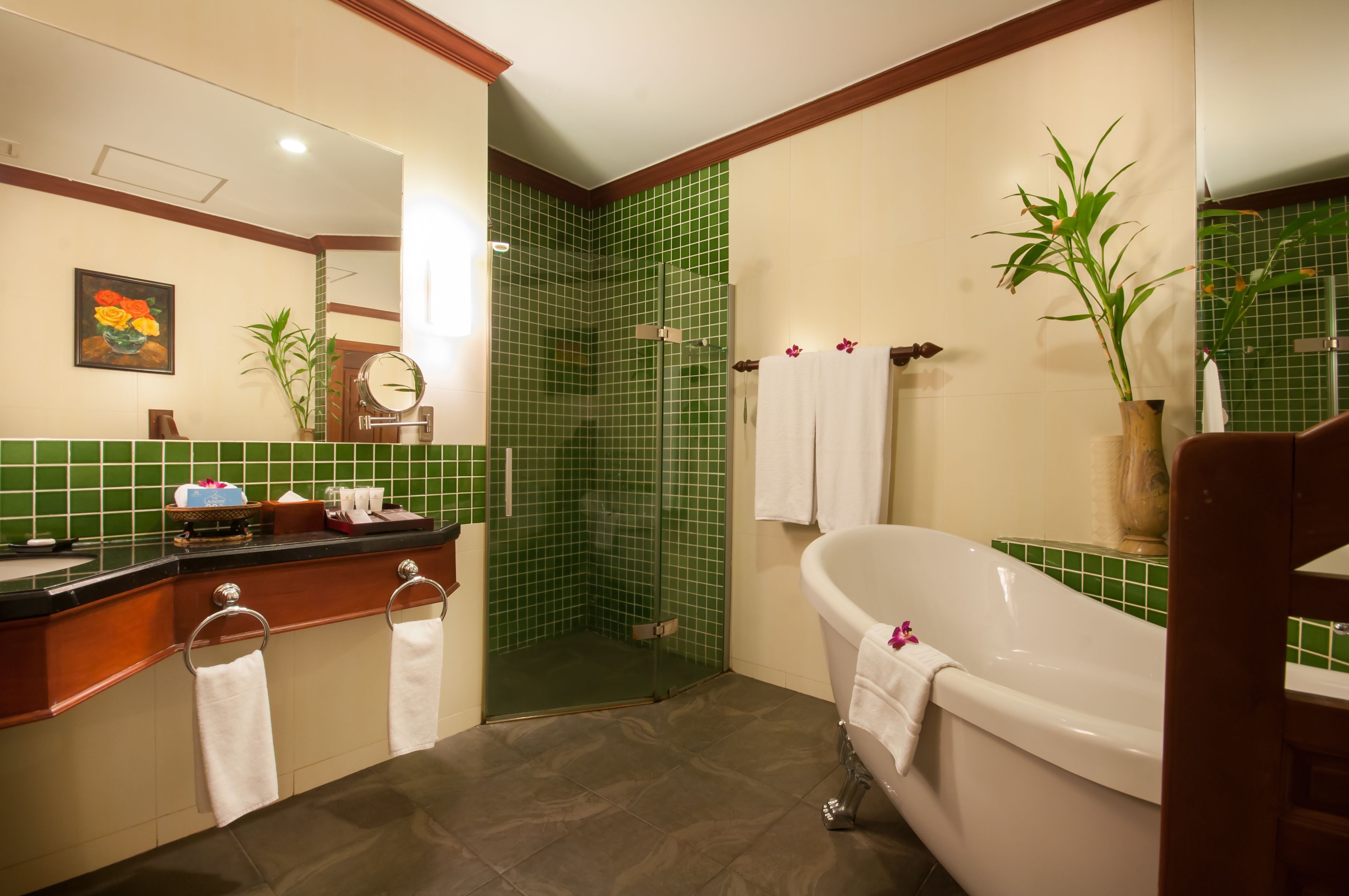 A bathroom with a bathtub, a shower, and a vanity with a mirror.