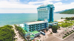 A hotel with a modern design, featuring a prominent tower and a lower building with a green roof. - Seagull Hotel (Quy Nhon Nam)