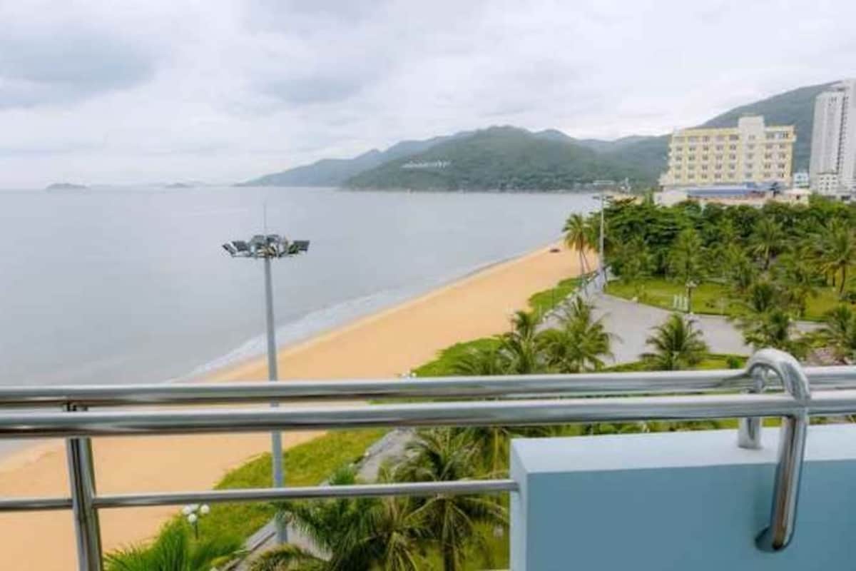 Una playa con vista al mar y un edificio a lo lejos.