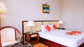 Una habitación de hotel con una cama de madera, dos mesitas de noche con lámparas, una silla y un cuadro en la pared.