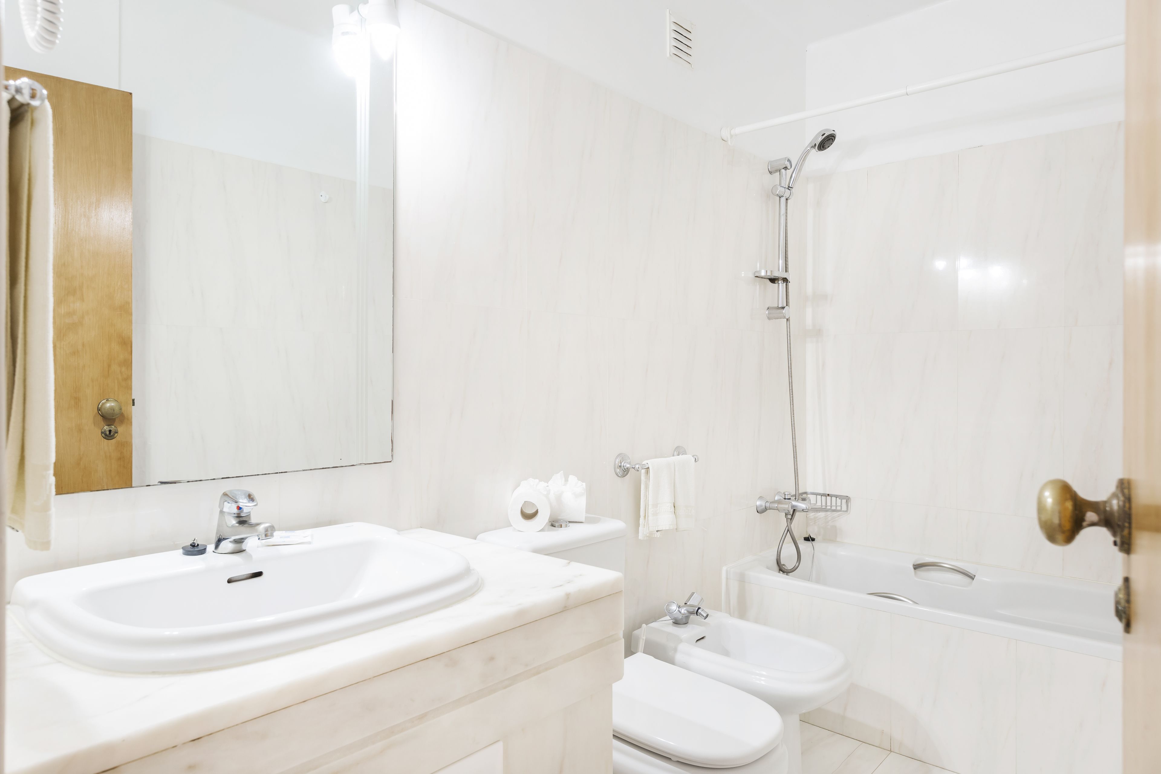 A modern bathroom with a double sink, a bathtub, and a shower.