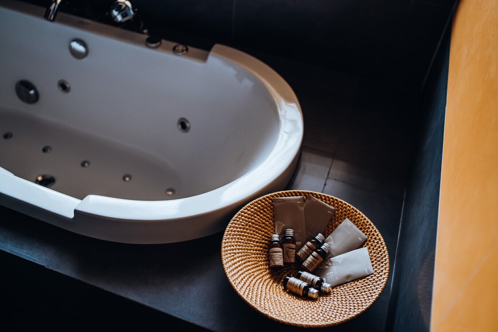 Ein Badezimmer mit einer Badewanne und einem gewobenen Korb mit Pflegeprodukten.