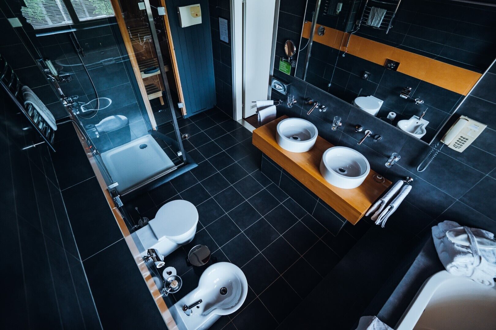 Un baño moderno con dos lavamanos, inodoro y ducha.