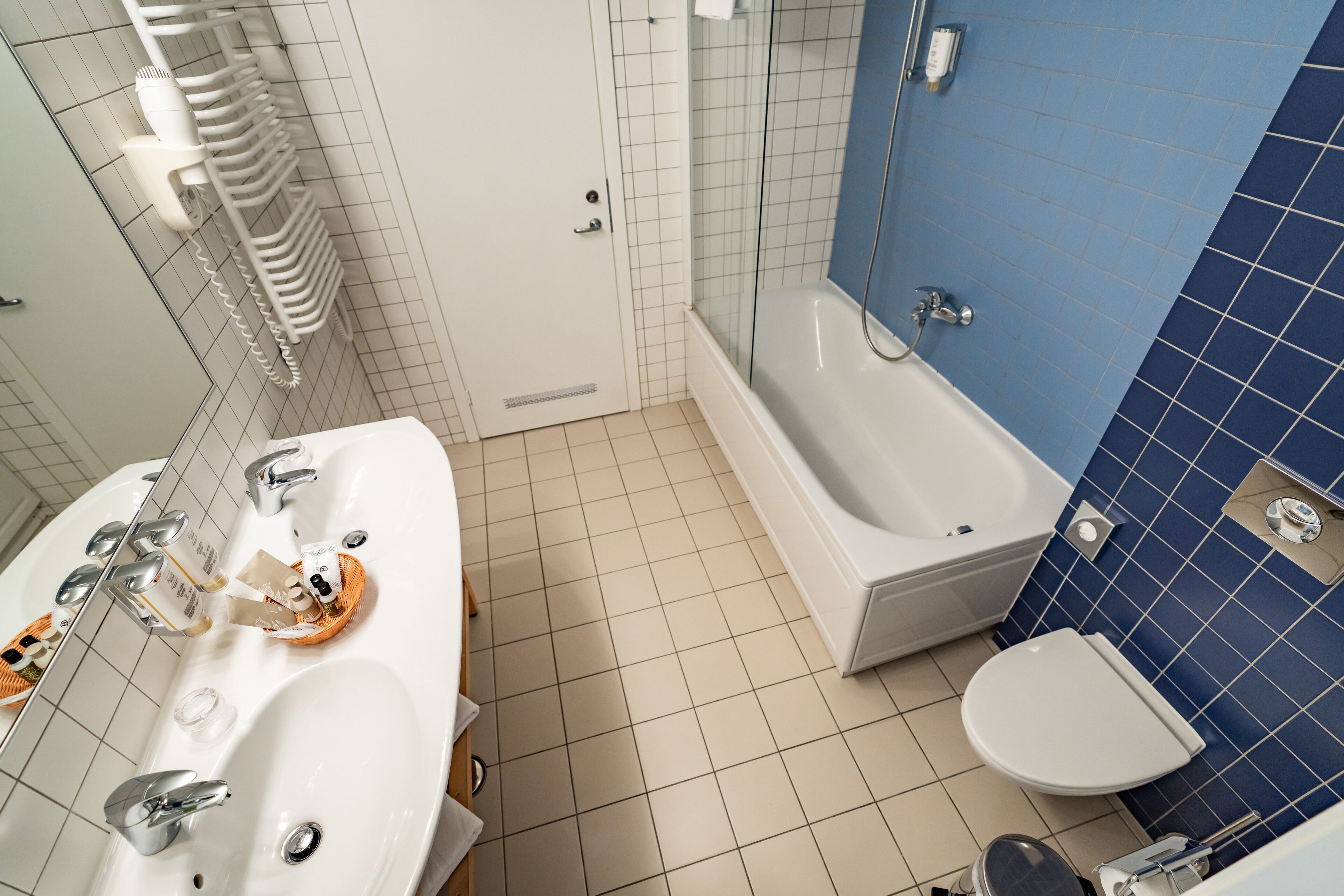 A bathroom with a white sink, a bathtub, and a toilet.