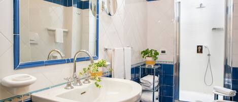 A bathroom with a sink, mirror, and shower.
