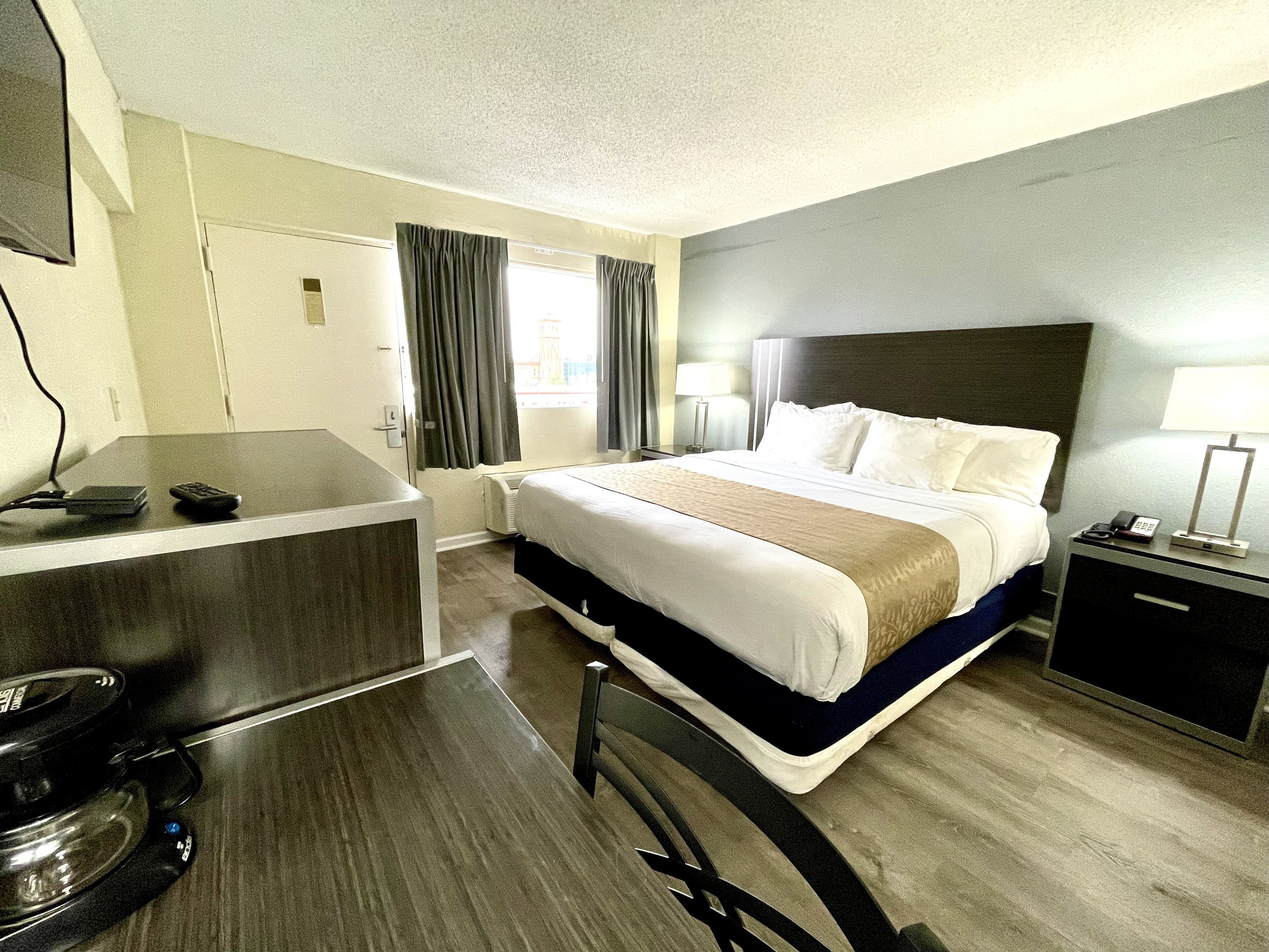 Une chambre d’hôtel avec un lit, un bureau et une chaise.