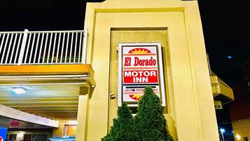 Segnaletica di motel per 'El Dorado Motor Inn' con un parcheggio multipiano sullo sfondo.