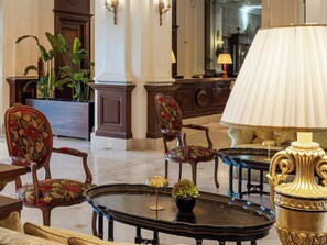 A lobby with ornate furniture, a large mirror, and a potted plant. - Grecotel Larissa Imperial (Larissa)