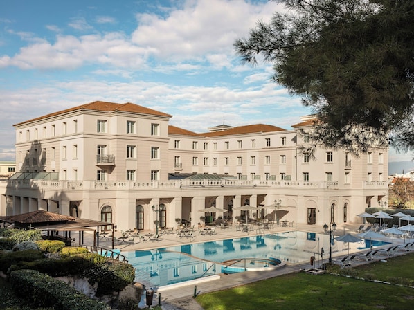 Un grand bâtiment doté d’une piscine, d’un espace extérieur aménagé et d’un jardin bien entretenu.