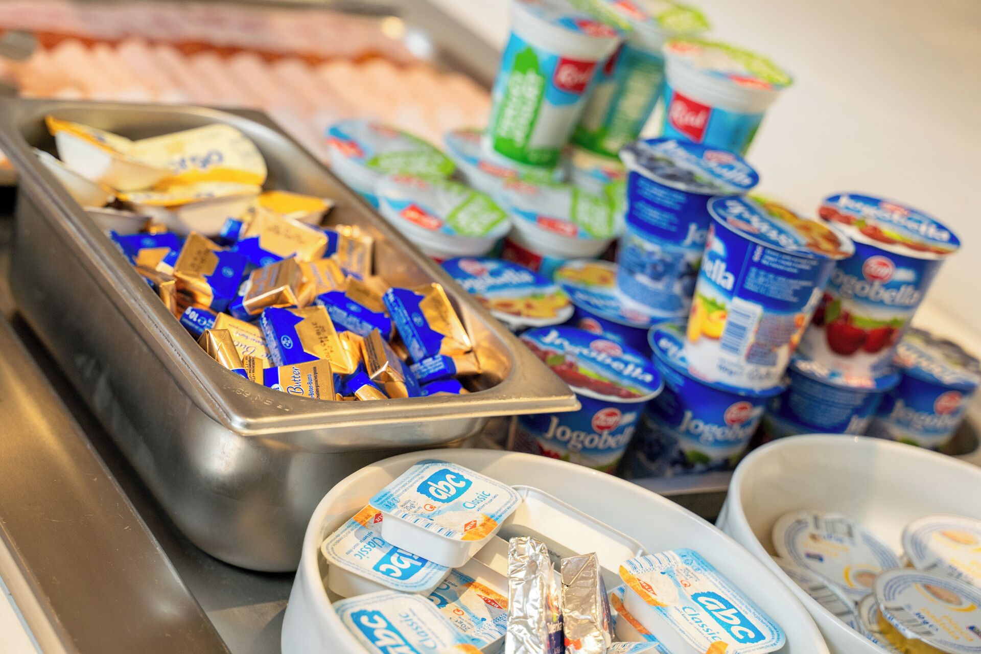 A buffet with various food items including butter, yogurt, and other dairy products.