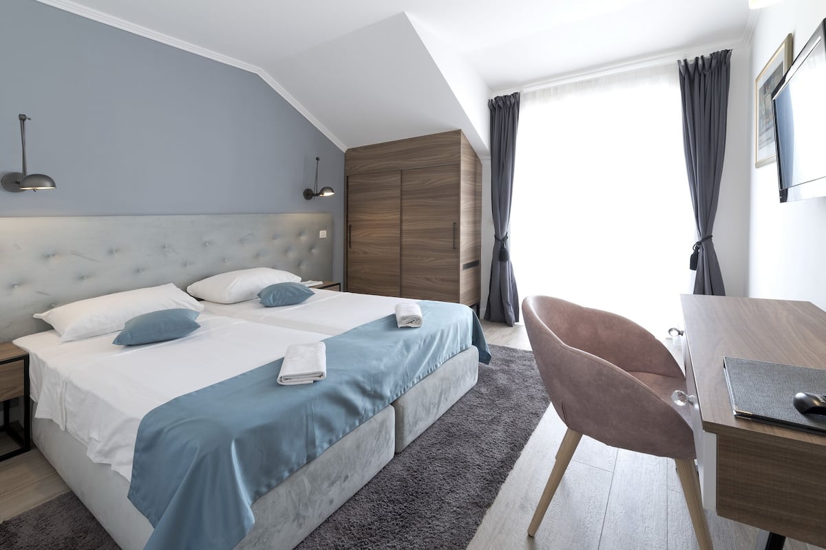 Kamer, 1 twee- of 2 eenpersoonsbedden, gedeeltelijk uitzicht op zee | Een minibar, een kluis op de kamer, een bureau, verduisterende gordijnen
