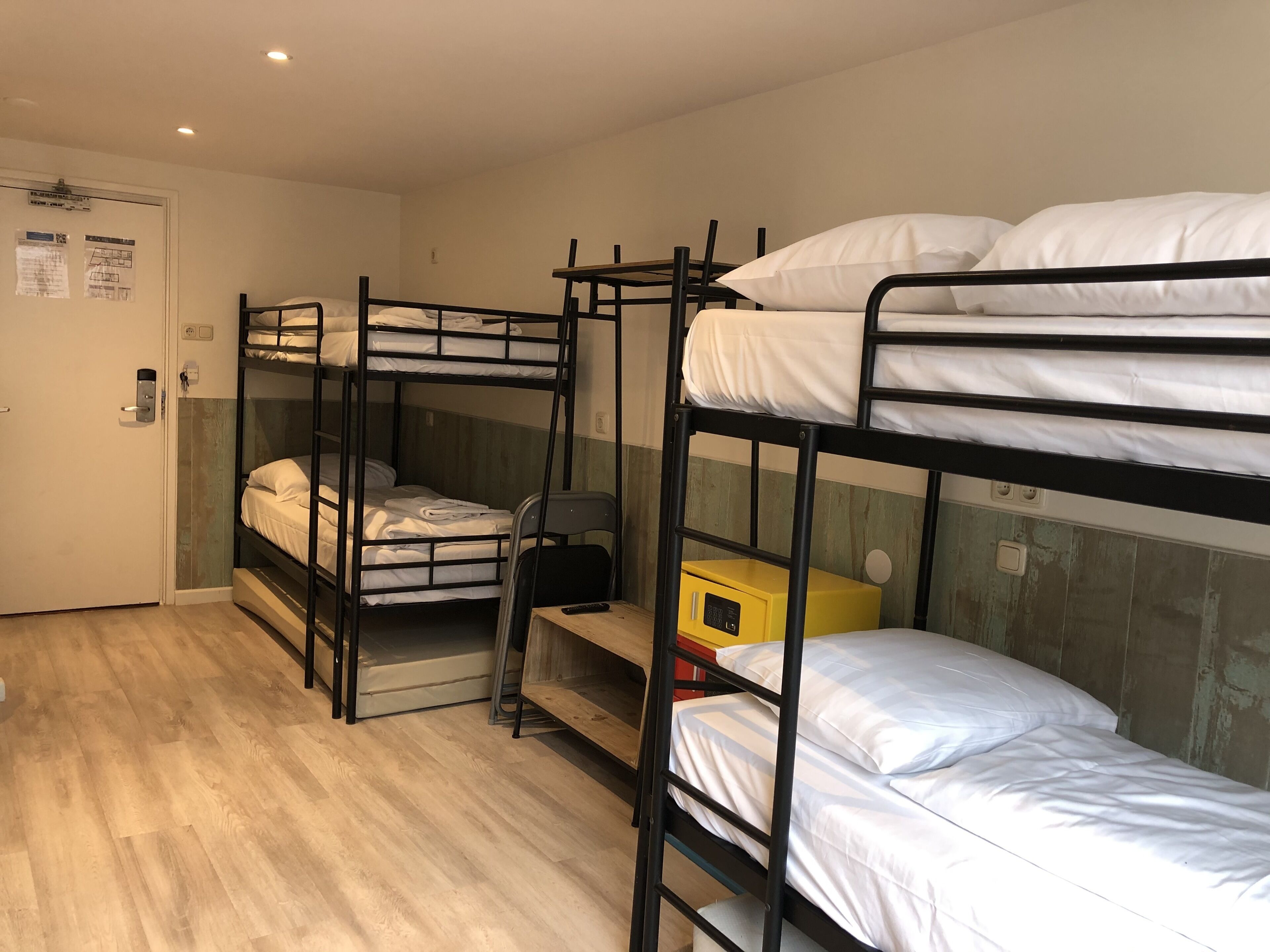 Une chambre de dortoir avec des lits superposés, un bureau et une chaise.