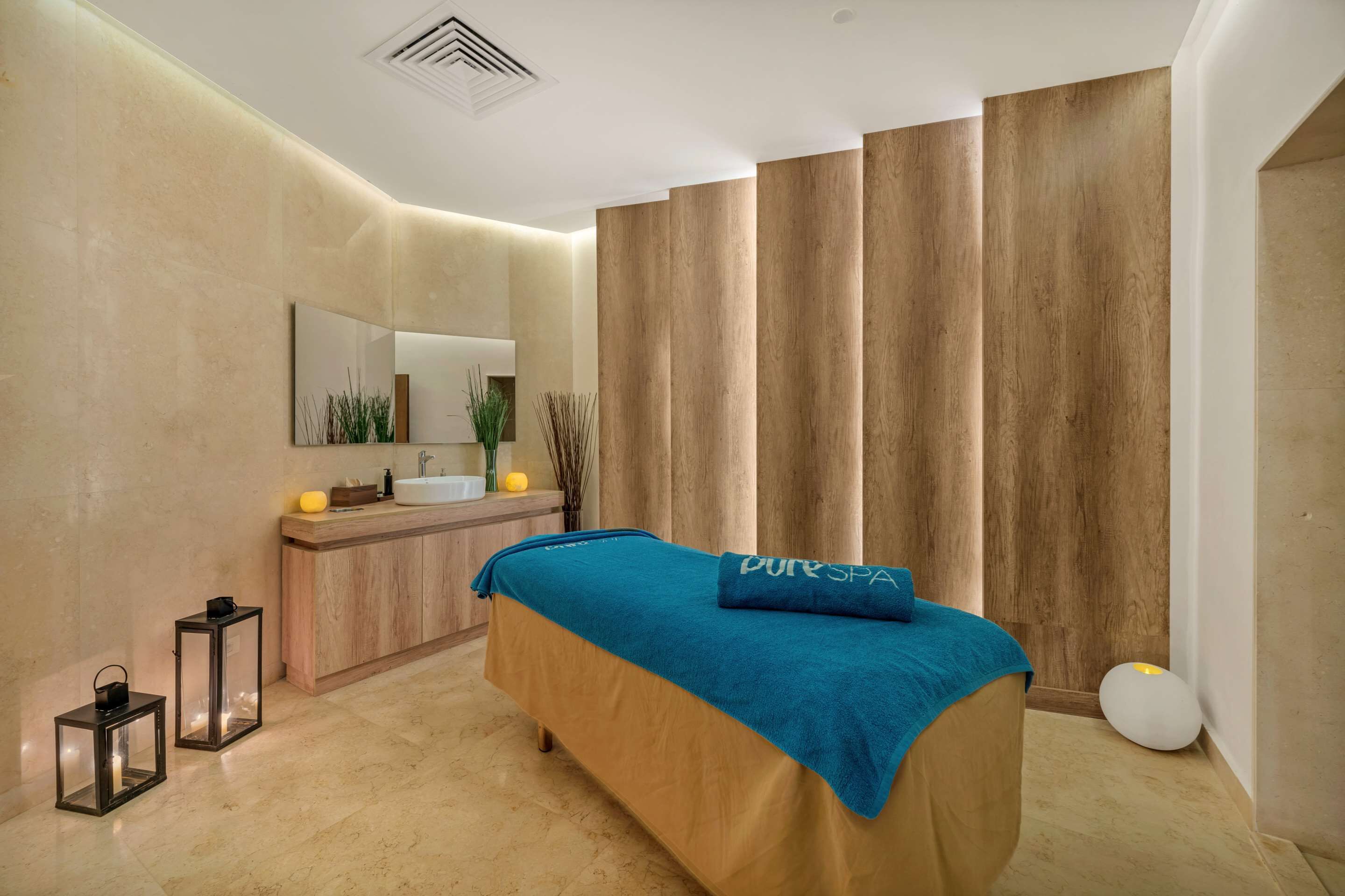 Un dormitorio moderno con una cama, un tocador con espejo y un amplio ventanal con cortinas.