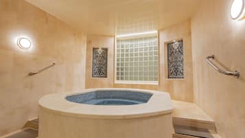 Bathroom features a bathtub, decorative tiles, and a bench.