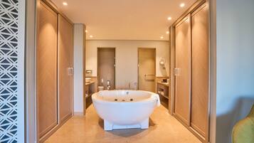Ein modernes Badezimmer mit freistehender Badewanne, Holzschränken und einem geometrischen Wanddesign.