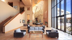 A spacious lobby with a staircase, seating area, and large windows. - Hotel Fuerte El Rompido (Cartaya)