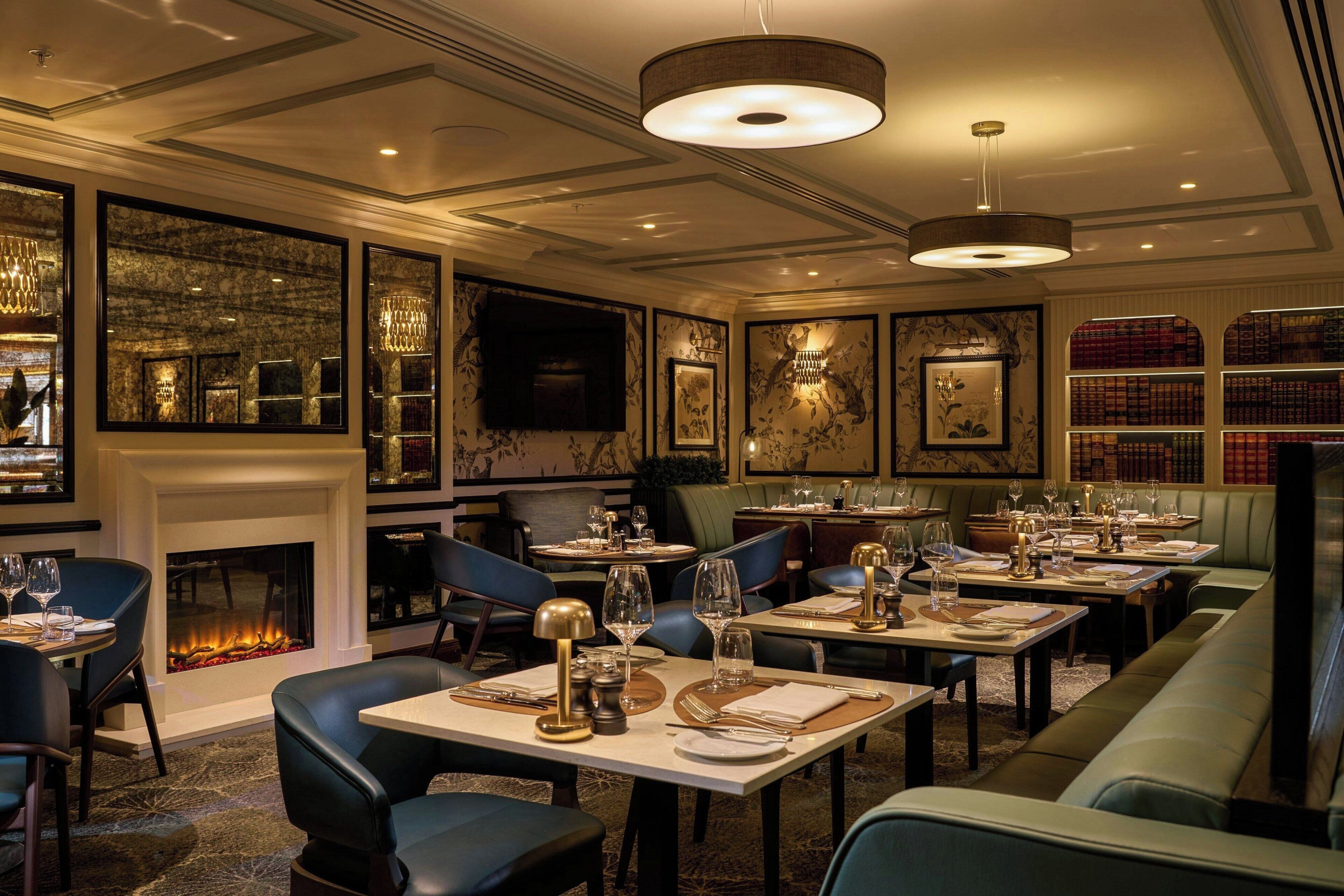 A restaurant with multiple dining tables, chairs, and a fireplace.