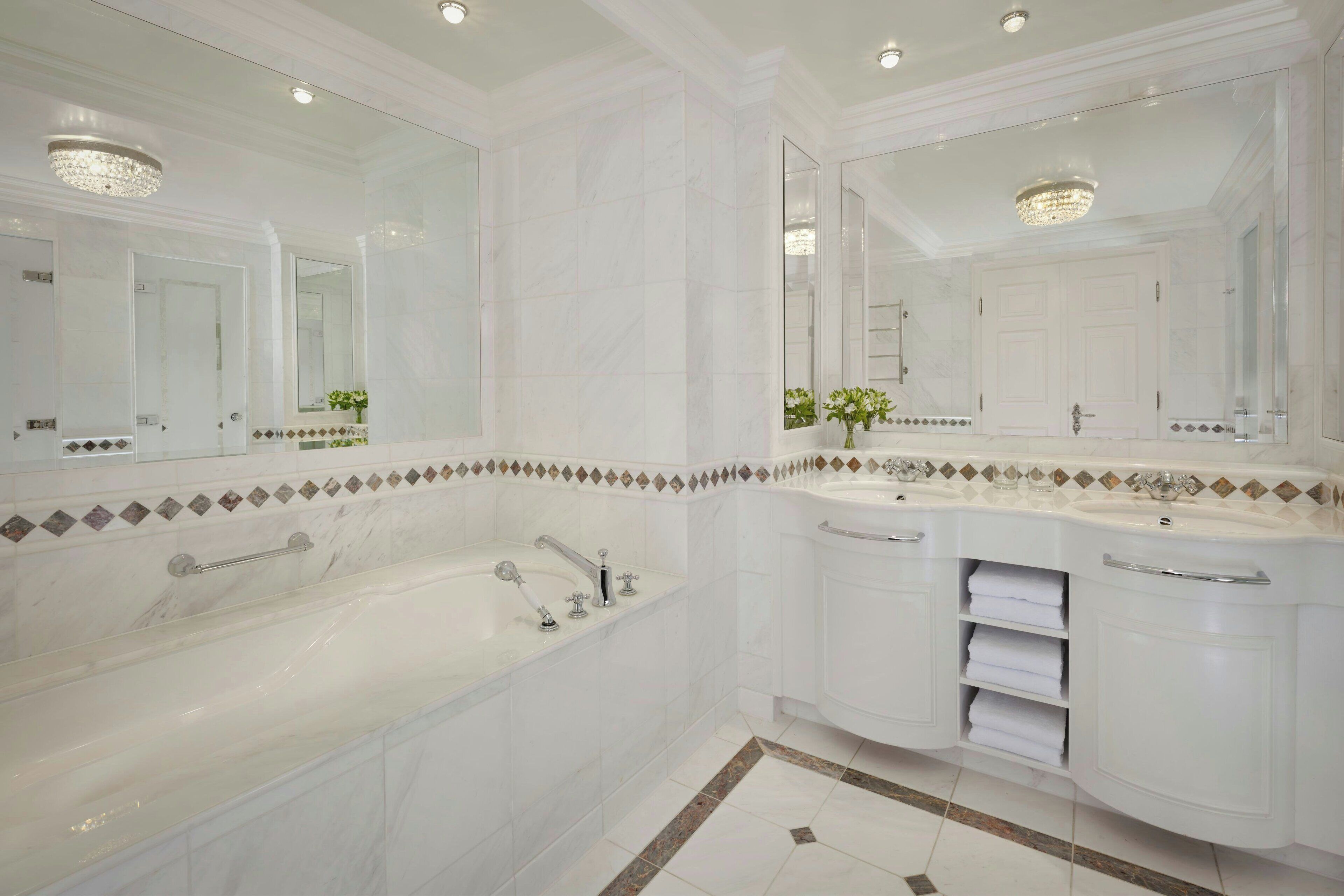 Un baño lujoso con una bañera grande, un lavabo doble y un espejo amplio.