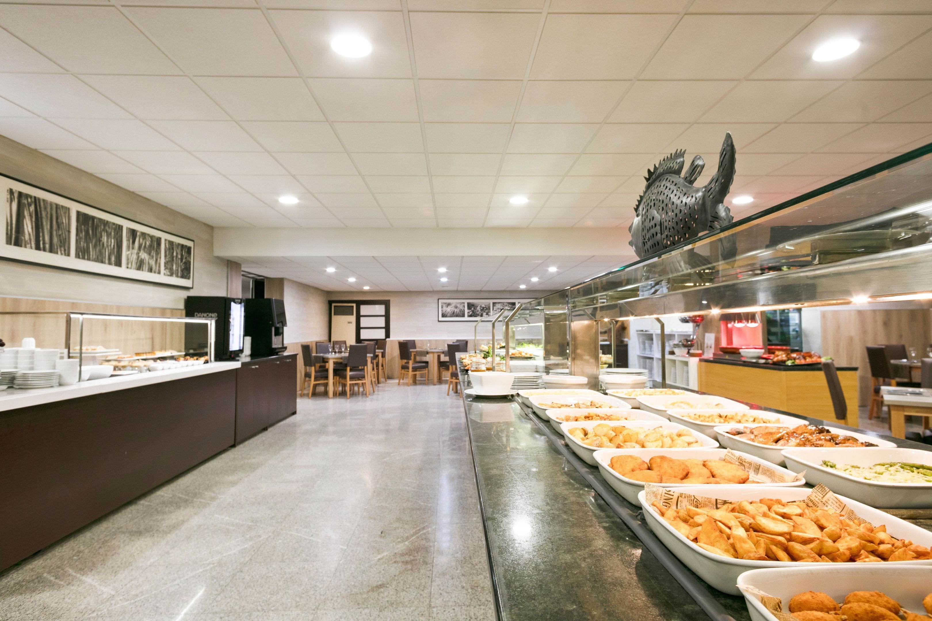 Ein Bereich mit Buffet und verschiedenen Speisen, ein Empfangsbereich und Sitzmöglichkeiten.