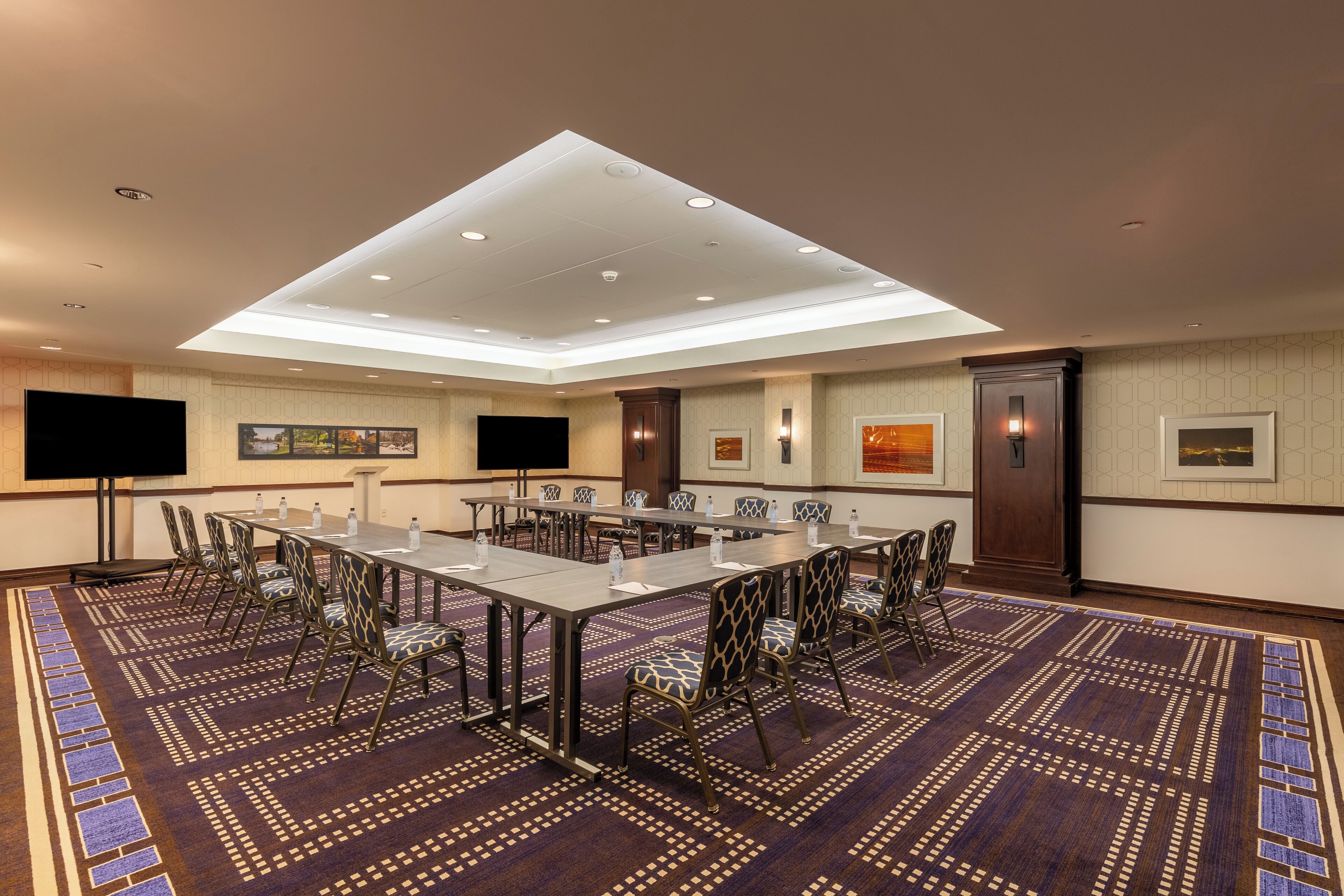 A conference room with a long table, chairs, and a flat-screen TV.