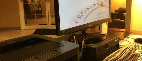 Una reception con una scrivania, un monitor che mostra un messaggio del programma fedeltà, una stampante e una tastiera.