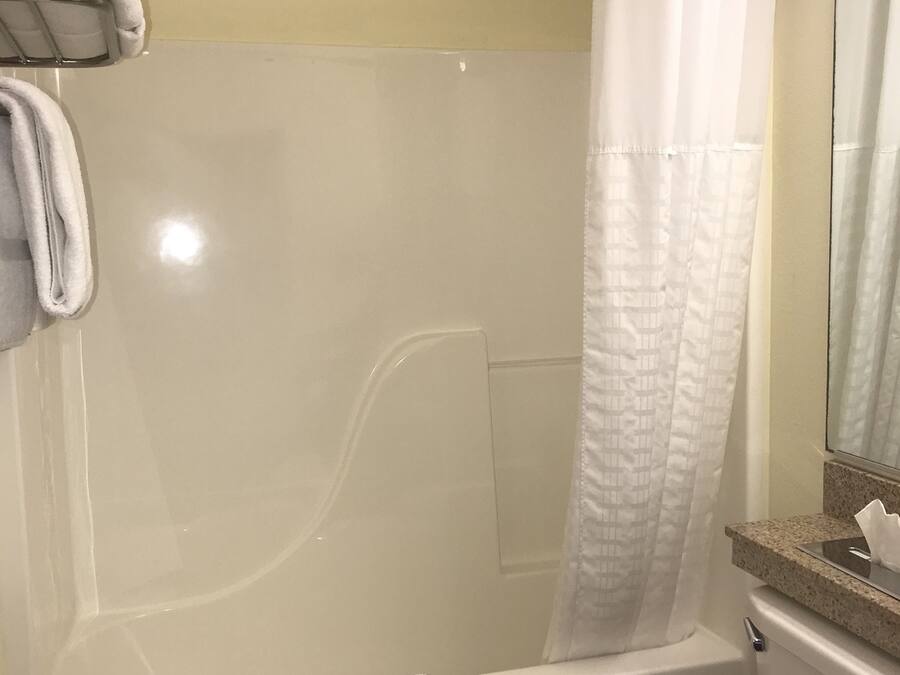 Un baño con ducha envuelta en vidrio, inodoro y toallero.
