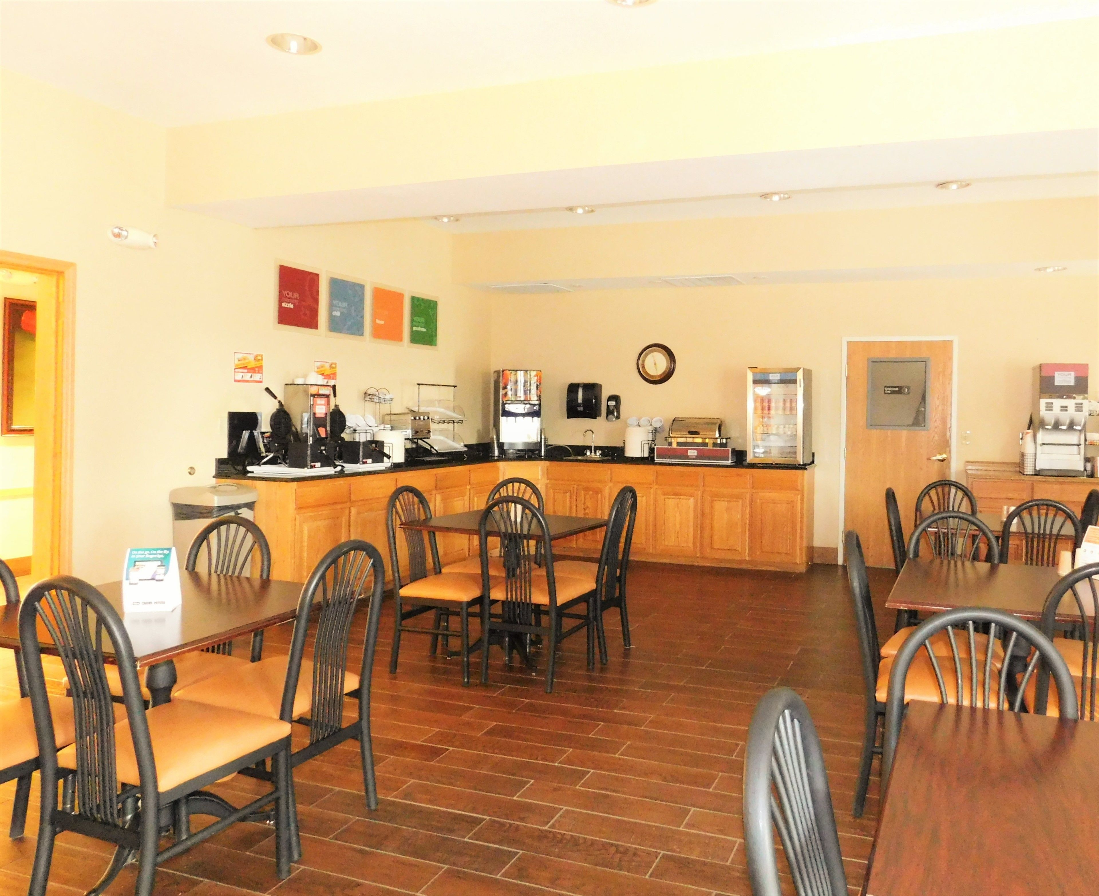 A restaurant with a counter, chairs, and tables.