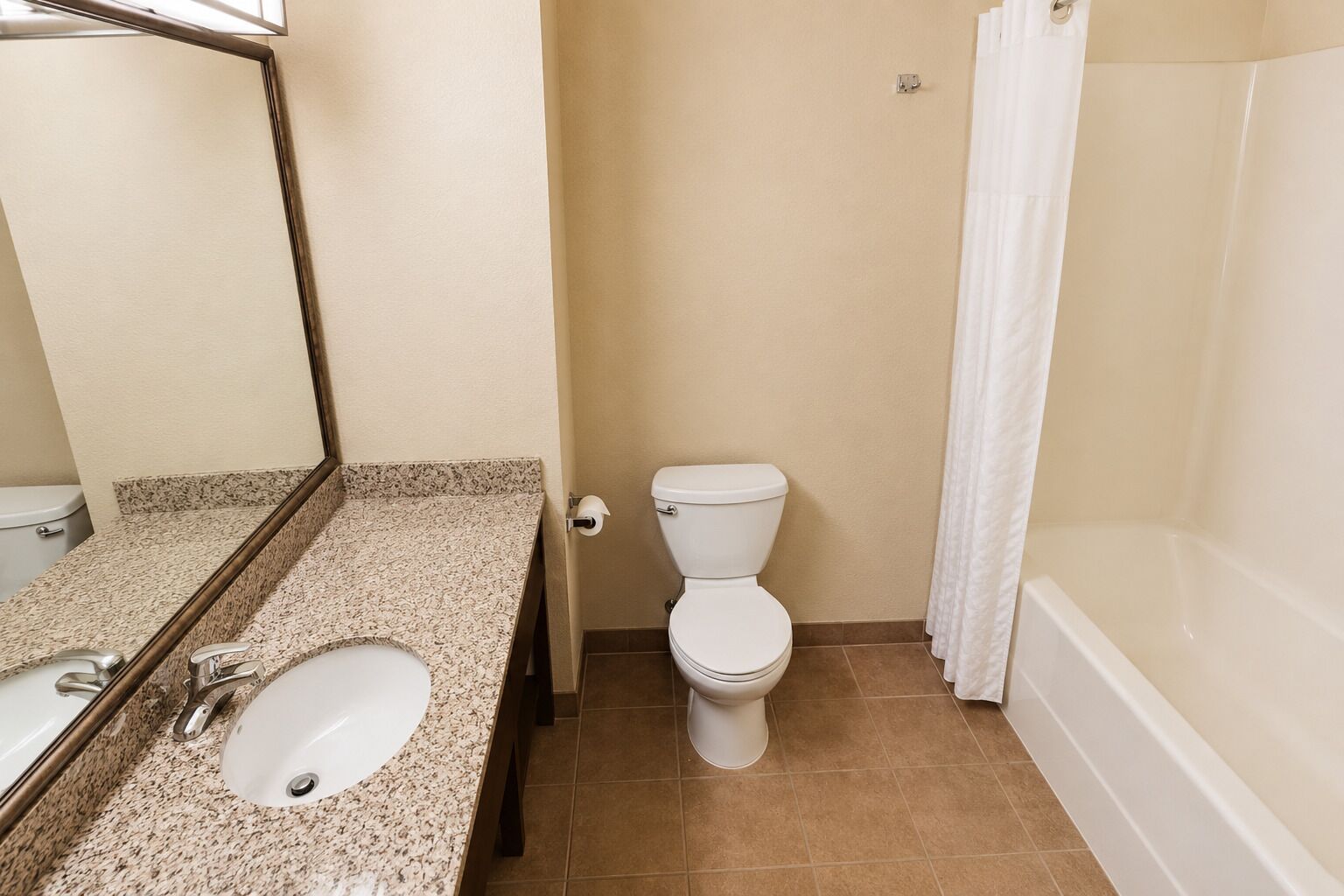 A bathroom with a sink, toilet, and bathtub.