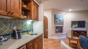 Una cucina con pensili in legno, zoccolo in piastrelle e piano cottura integrato.