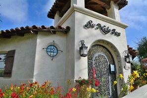 Un edificio con un cartel que dice "El Nido Inn" y una puerta decorativa con un diseño de hierro forjado.