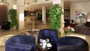 A spacious lobby with high ceilings, a chandelier, a reception desk, and seating areas. - Swiss Inn Pyramids Golf Resort (6th of October City)