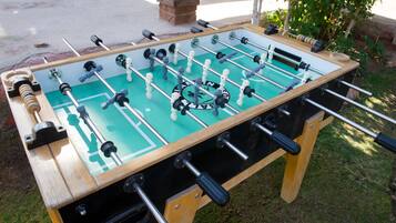 A foosball table with a wooden frame and a green playing surface.