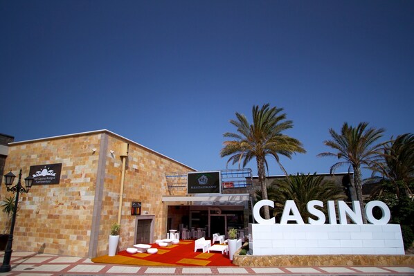 Un edificio con un cartel que dice "CASINO" y una alfombra roja que conduce a la entrada.