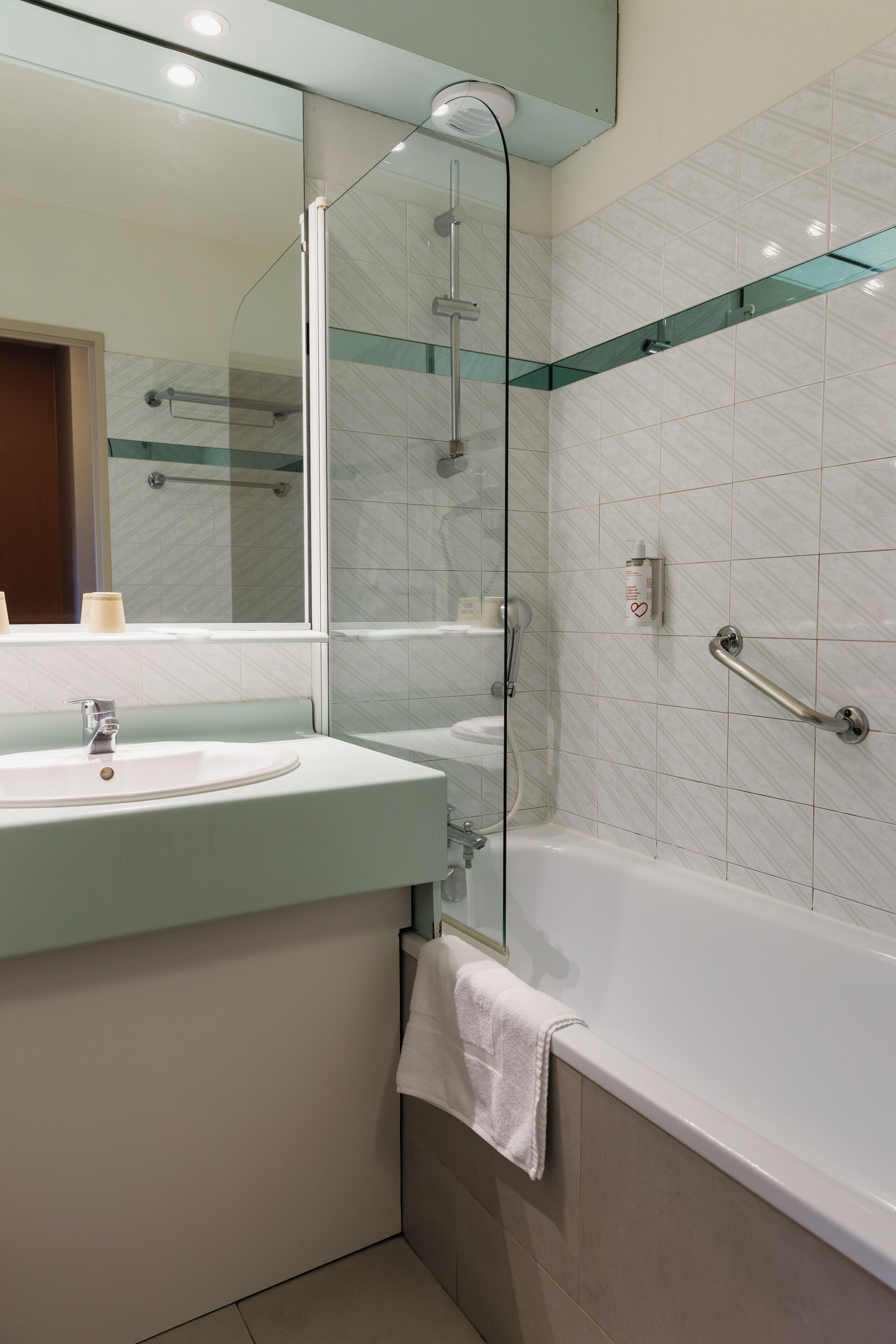 A modern bathroom with a glass-enclosed shower, a sink, and a bathtub.