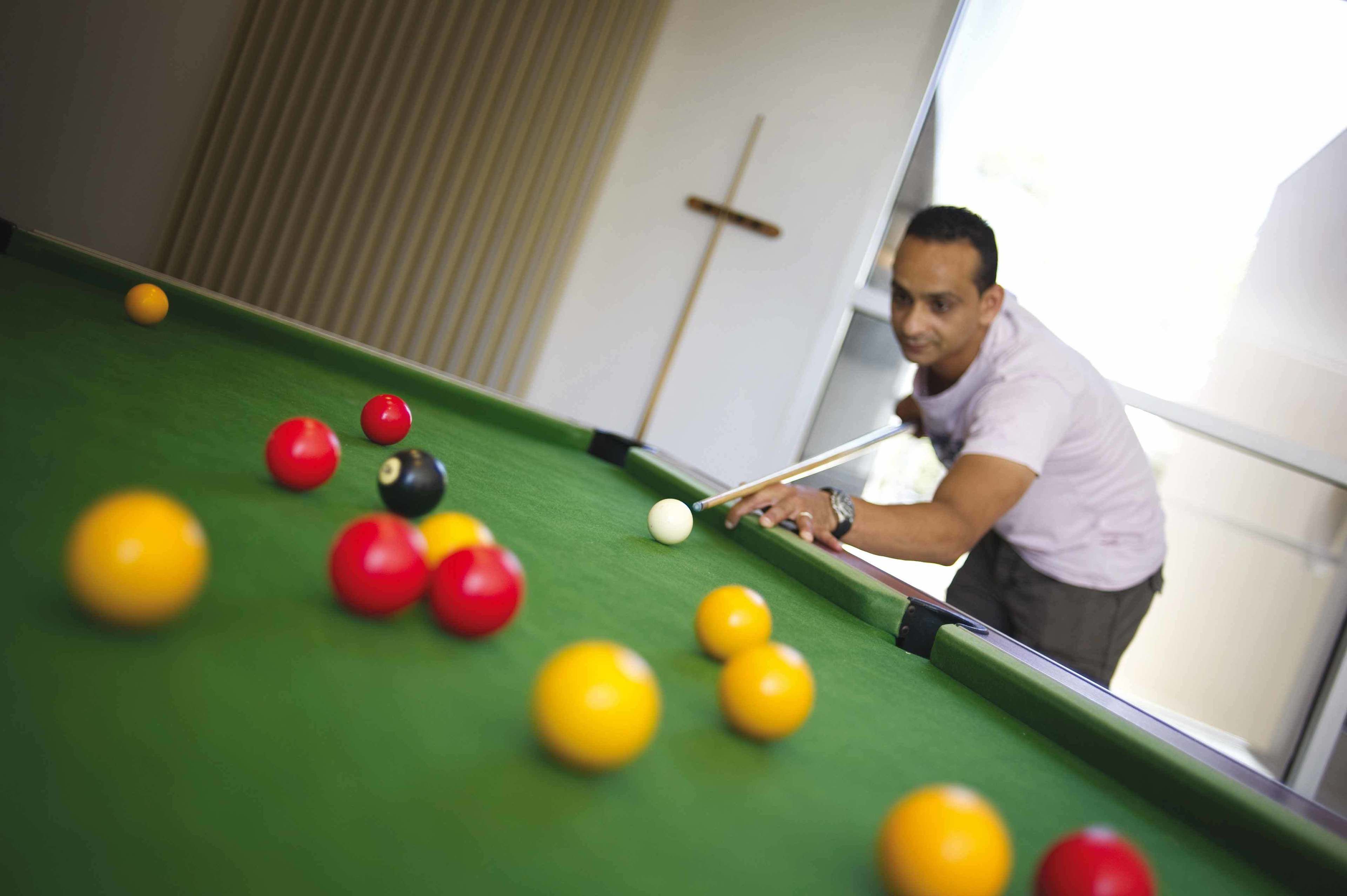A billiards table with balls and a cue stick.