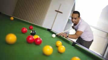 Une table de billard avec des billes et une queue de billard.