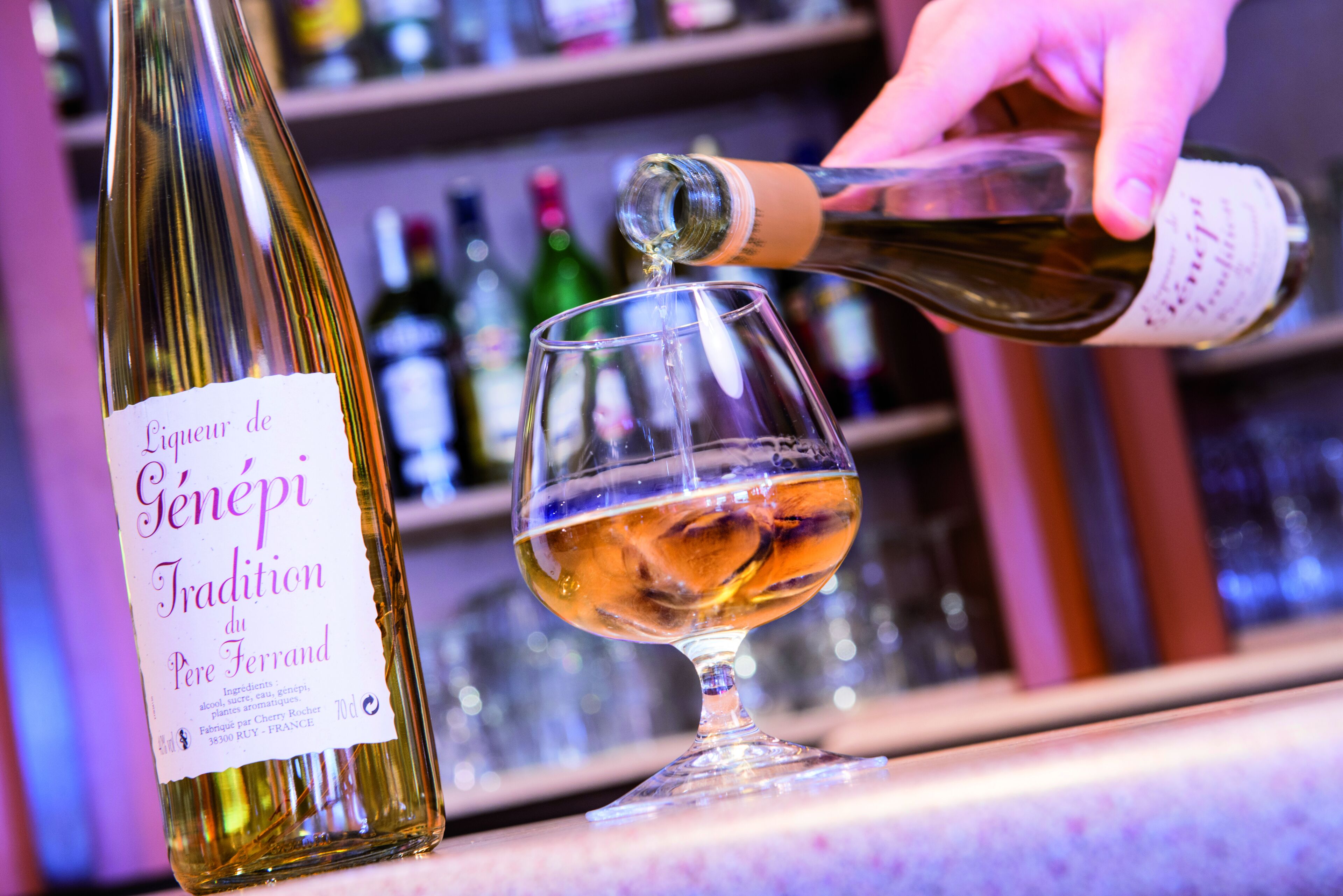 A bottle of wine being poured into a glass.